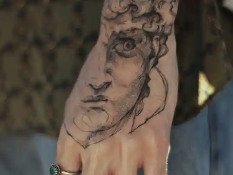 A tattoo of a face, on a hand