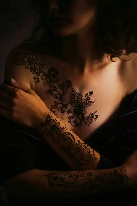 A floral tattoo pattern across the chest and arms