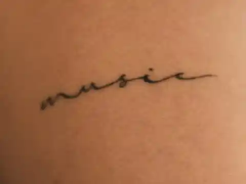 A tattoo of the word music written in cursive