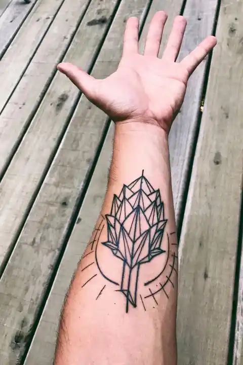 A forearm tattoo of a leaf in sunlight