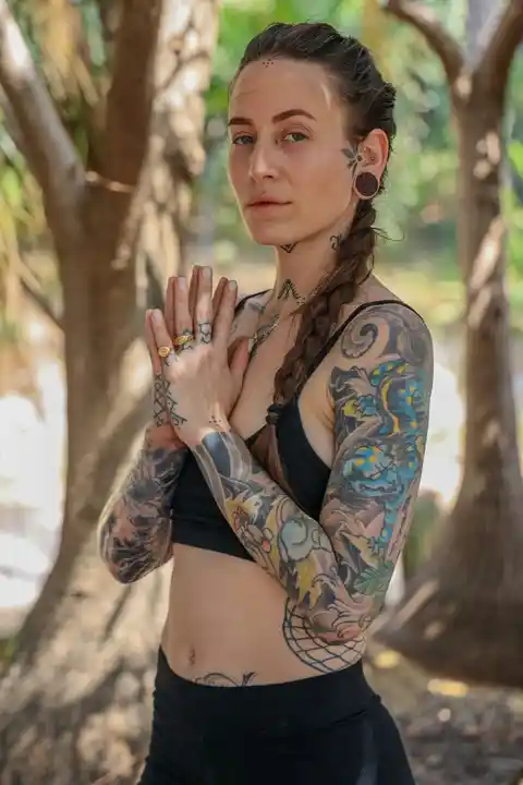 A sleeve tattoo on a woman in the forest