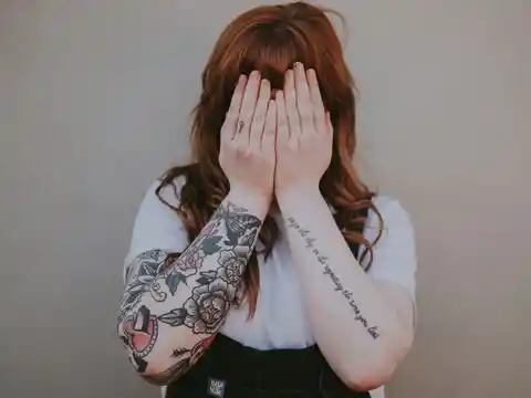 A woman displays her forearm tattoos