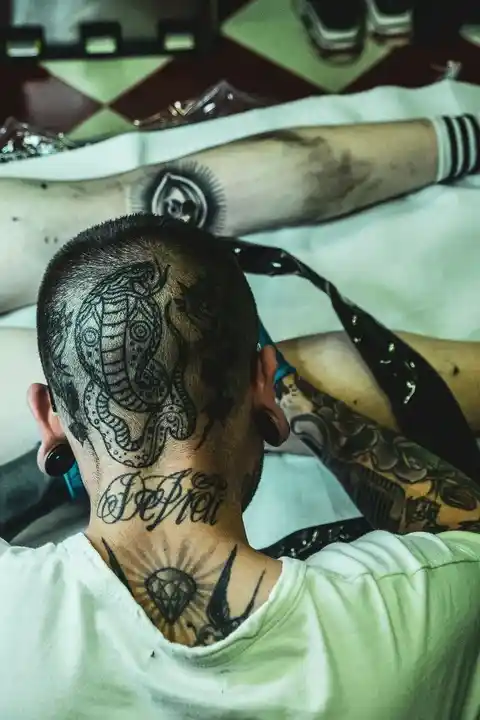 A tattoo on the back of a person's head and neck