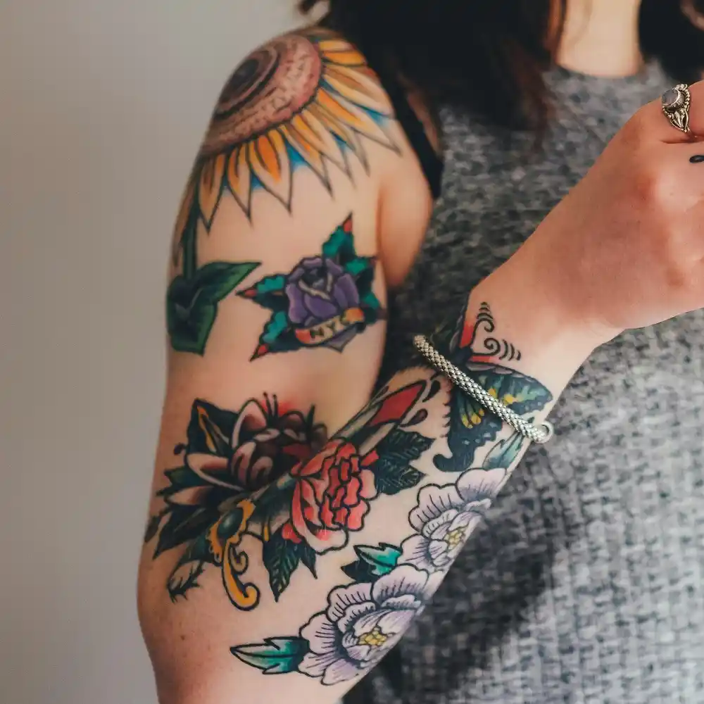 A woman with colourful, floral tattoos on her arm