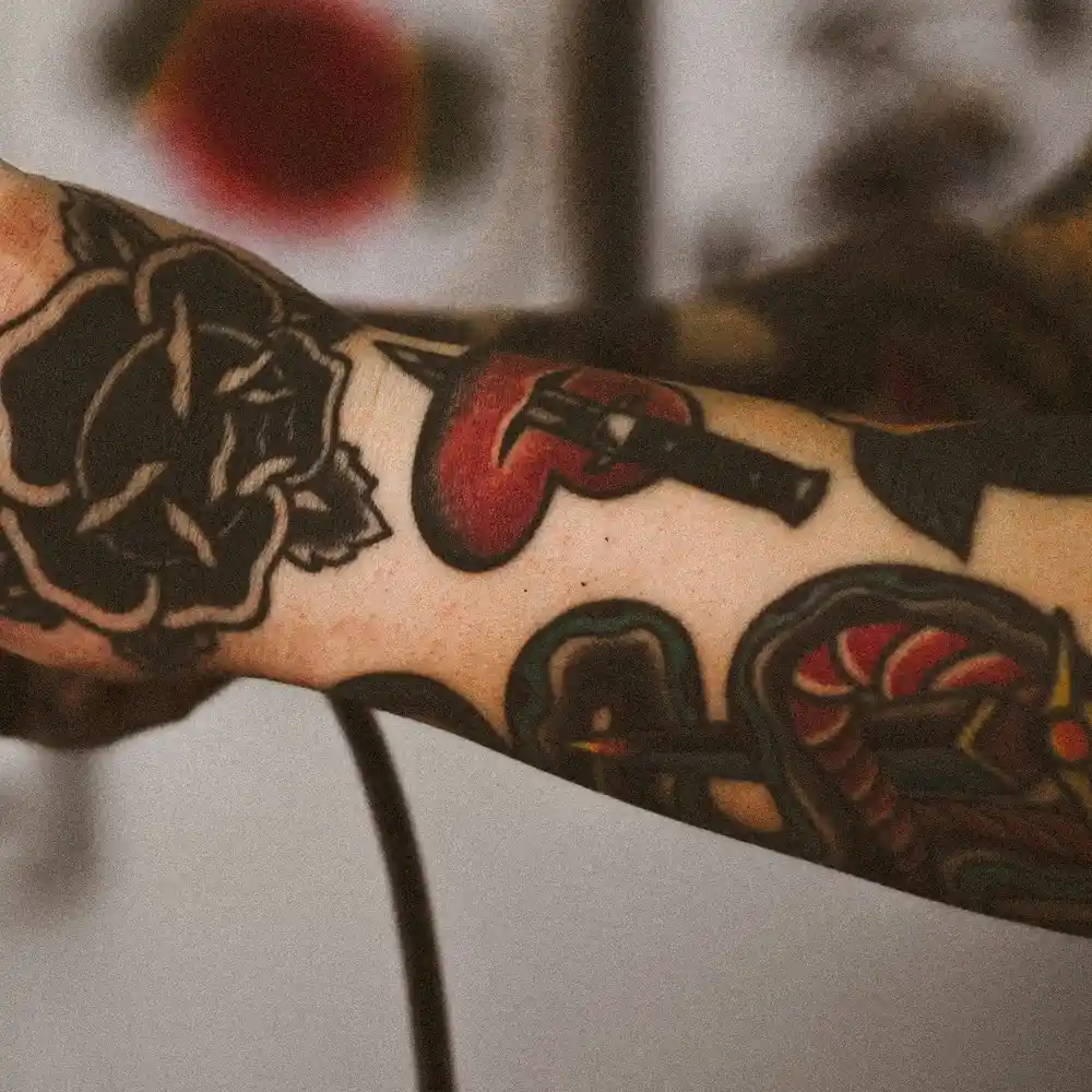 A red heart with a dagger through it tattoo