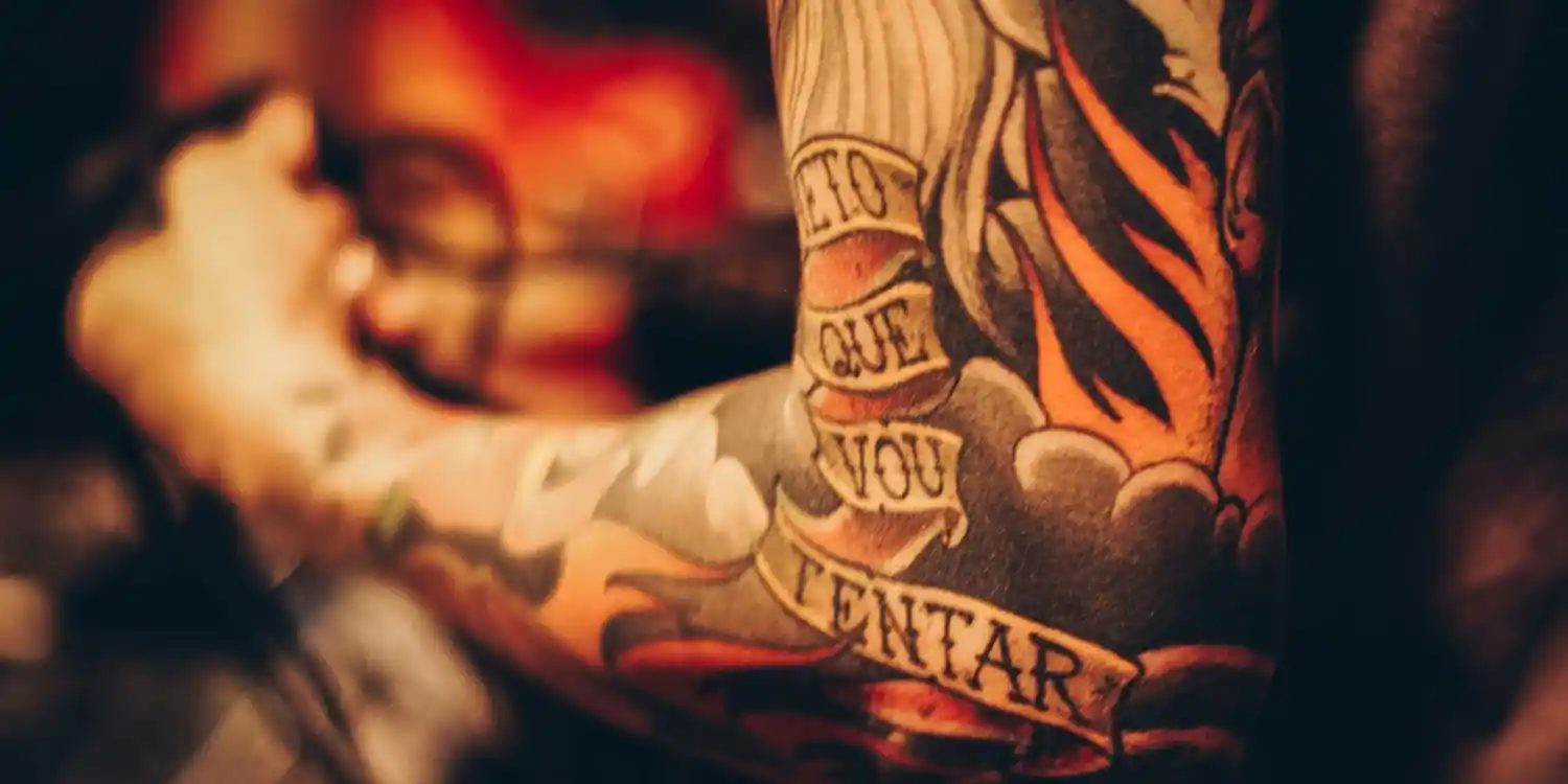 A colourful sleeve tattoo with text